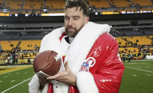 Kansas City Chiefs tight end Travis Kelce (87) holds a football after an NFL football game against the Pittsburgh Steelers, Wednesday, Dec. 25, 2024, in Pittsburgh. (AP Photo/Matt Freed)