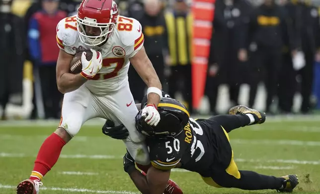 Pittsburgh Steelers linebacker Elandon Roberts (50) tackles Kansas City Chiefs tight end Travis Kelce (87) during the second half of an NFL football game, Wednesday, Dec. 25, 2024, in Pittsburgh. (AP Photo/Matt Freed)