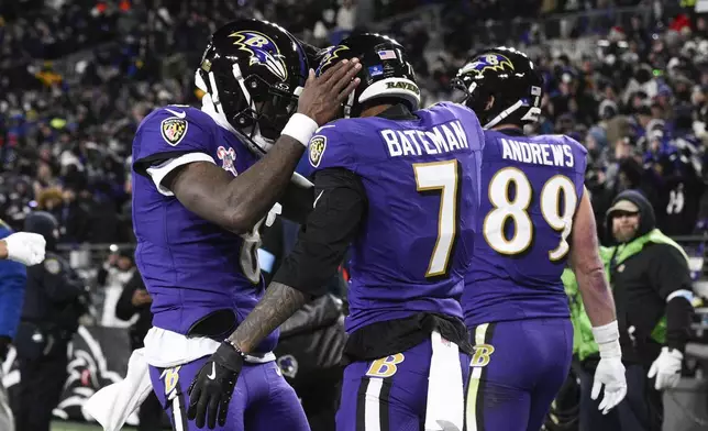 Baltimore Ravens quarterback Lamar Jackson, left, and wide receiver Rashod Bateman (7) react after connecting for a touchdown pass and catch against the Pittsburgh Steelers during the first half of an NFL football game, Saturday, Dec. 21, 2024, in Baltimore. (AP Photo/Nick Wass)