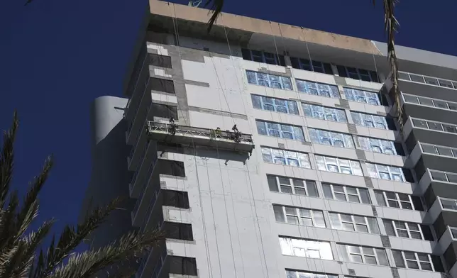 Workers make repairs to the facade of the Parker Tower Condo, designed by architect Morris Lapidus, Thursday, Dec. 5, 2024, in Hallandale Beach, Fla. (AP Photo/Marta Lavandier)