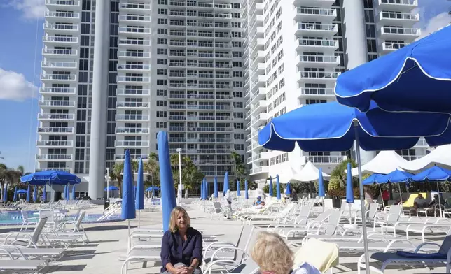 Kelli Roiter talks to her mother Hilda on the pool deck of their condominium building, Thursday, Dec. 5, 2024, in Hallandale Beach. (AP Photo/Marta Lavandier)