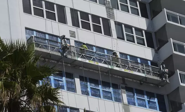 Workers make repairs to the facade of the Parker Tower Condo, designed by architect Morris Lapidus, Thursday, Dec. 5, 2024, in Hallandale Beach, Fla. (AP Photo/Marta Lavandier)