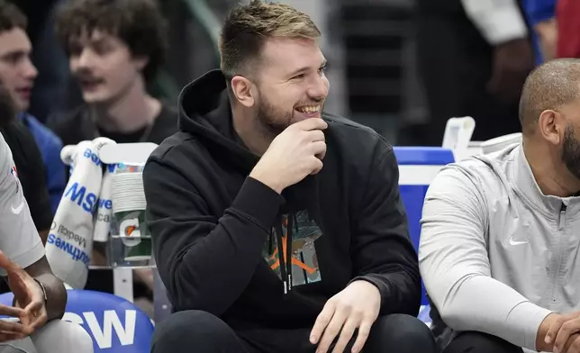 Dallas Mavericks' Luka Doncic smiles as he watches play against the Los Angeles Clippers in the first half of an NBA basketball game in Dallas, Thursday, Dec. 19, 2024. (AP Photo/Tony Gutierrez)