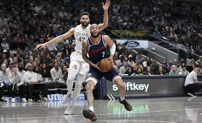 Los Angeles Clippers guard Amir Coffey gets past Dallas Mavericks forward Maxi Kleber (42) on a drive to the basket in the first half of an NBA basketball game in Dallas, Thursday, Dec. 19, 2024. (AP Photo/Tony Gutierrez)