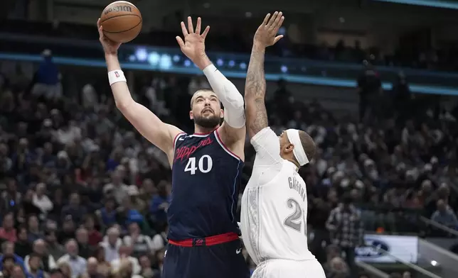 Los Angeles Clippers center Ivica Zubac (40) shoots as Dallas Mavericks' Daniel Gafford (21) defends in the first half of an NBA basketkbal lgame in Dallas, Thursday, Dec. 19, 2024. (AP Photo/Tony Gutierrez)