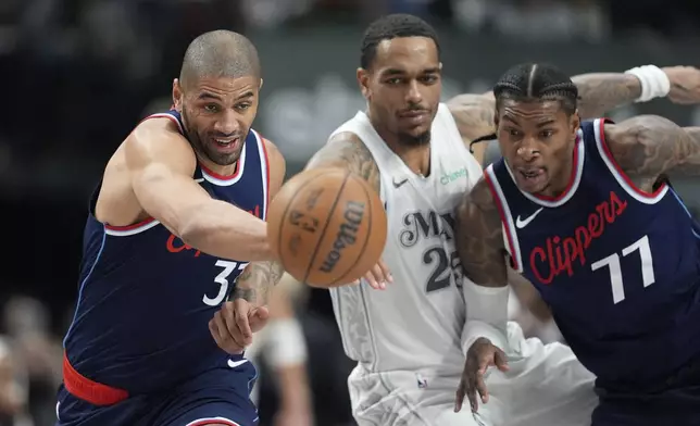 Los Angeles Clippers' Nicolas Batum (33), Dallas Mavericks' P.J. Washington, center, and Kevin Porter Jr. (77) sprint after a loose ball in the first half of an NBA basketball game in Dallas, Thursday, Dec. 19, 2024. (AP Photo/Tony Gutierrez)