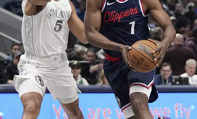 Los Angeles Clippers guard James Harden (1) drives to the basket as Dallas Mavericks guard Quentin Grimes (5) defends in the first half of an NBA basketball game in Dallas, Thursday, Dec. 19, 2024. (AP Photo/Tony Gutierrez)