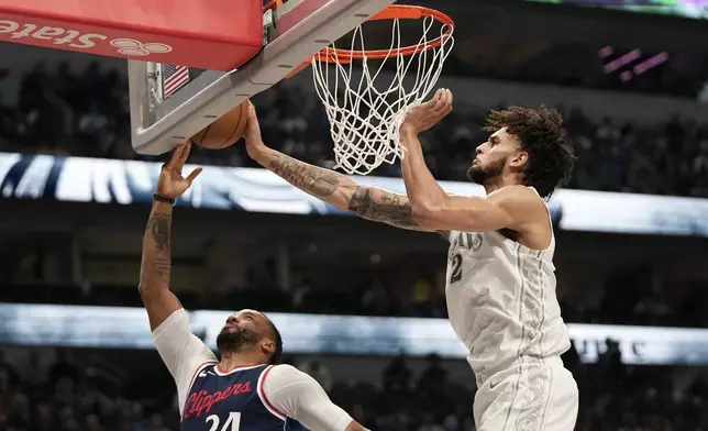 Los Angeles Clippers guard Norman Powell (24) has his shot blocked by Dallas Mavericks center Dereck Lively II, right, in the first half of an NBA basketball game in Dallas, Thursday, Dec. 19, 2024. (AP Photo/Tony Gutierrez)