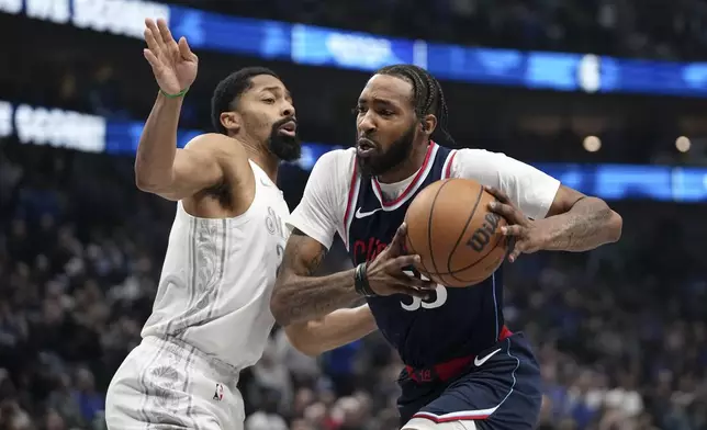 Los Angeles Clippers forward Derrick Jones Jr., right, works to the basket against Dallas Mavericks' Spencer Dinwiddie, left, in the first half of an NBA basketball game in Dallas, Thursday, Dec. 19, 2024. (AP Photo/Tony Gutierrez)