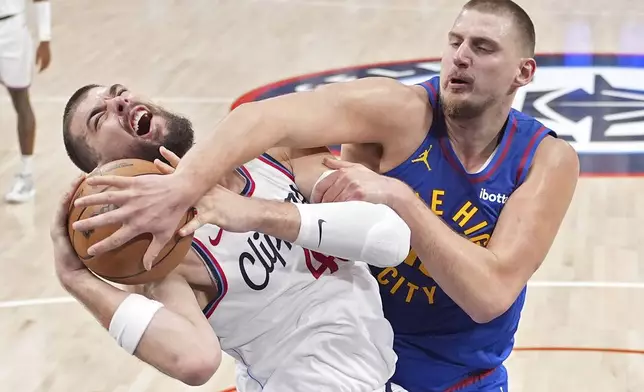 Denver Nuggets center Nikola Jokic, right, ties up Los Angeles Clippers center Ivica Zubac as Zubac tries to shoot during the first half of an NBA basketball game, Sunday, Dec. 1, 2024, in Inglewood, Calif. (AP Photo/Mark J. Terrill)