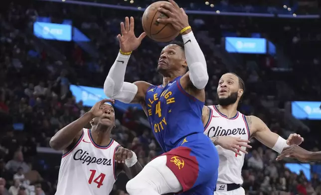 Denver Nuggets guard Russell Westbrook, center, soots as Los Angeles Clippers guard Terance Mann, left, and guard Amir Coffey defend during the first half of an NBA basketball game, Sunday, Dec. 1, 2024, in Inglewood, Calif. (AP Photo/Mark J. Terrill)