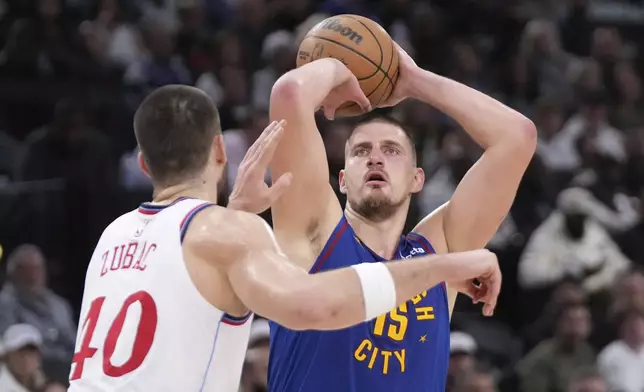 Denver Nuggets center Nikola Jokic, right, shoots as Los Angeles Clippers center Ivica Zubac defends during the first half of an NBA basketball game, Sunday, Dec. 1, 2024, in Inglewood, Calif. (AP Photo/Mark J. Terrill)