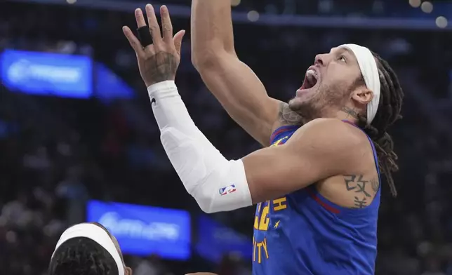 Denver Nuggets forward Aaron Gordon, right, shoots as Los Angeles Clippers guard Terance Mann defends during the first half of an NBA basketball game, Sunday, Dec. 1, 2024, in Inglewood, Calif. (AP Photo/Mark J. Terrill)