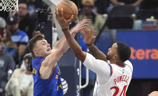 Los Angeles Clippers guard Norman Powell, right, shoots as Denver Nuggets guard Christian Braun defends during the first half of an NBA basketball game, Sunday, Dec. 1, 2024, in Inglewood, Calif. (AP Photo/Mark J. Terrill)