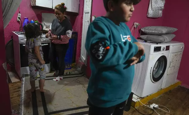 Rukiye Sahin, 28, talks to her daughter Dilan, 5, near her son Atakan, 11, in the family's one-room apartment in the Tarlabasi neighborhood in Istanbul, Turkey, Wednesday, Dec. 4, 2024. (AP Photo/Francisco Seco)