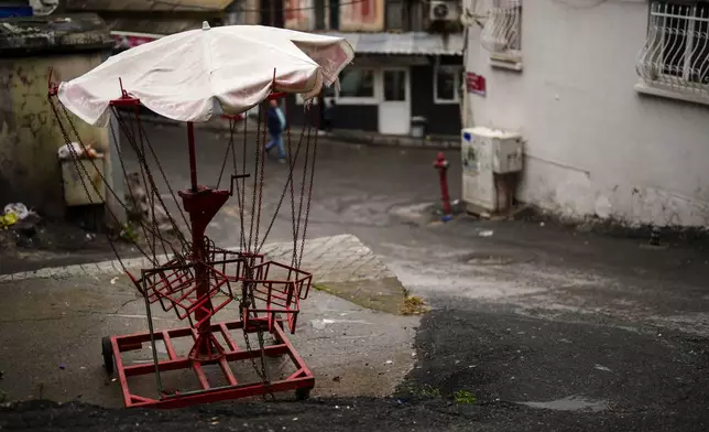 A manually operated carousel is seen in the Tarlabasi neighborhood in Istanbul, Turkey, Wednesday, Dec. 4, 2024. (AP Photo/Francisco Seco)