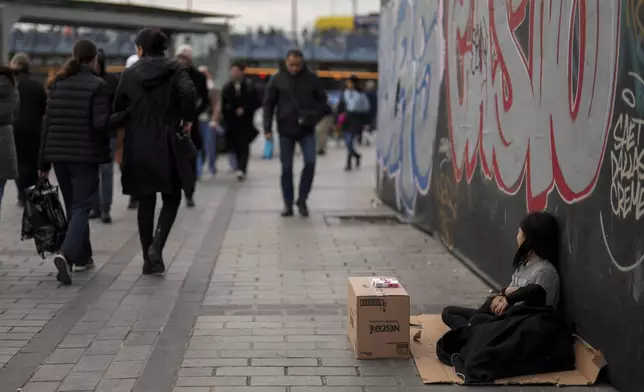 Young girls sell tissues to passersby on the Karakoy sea promenade in Istanbul, Turkey, Saturday, Dec. 7, 2024. (AP Photo/Francisco Seco)