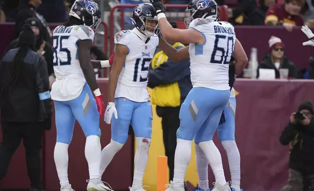 Tennessee Titans wide receiver Nick Westbrook-Ikhine (15) celebrates his touchdown with teammates tChig Okonkwo (85) and Daniel Brunskill (60) during the first half of an NFL football game against the Washington Commanders, Sunday, Dec. 1, 2024, in Landover, Md. (AP Photo/Matt Slocum)