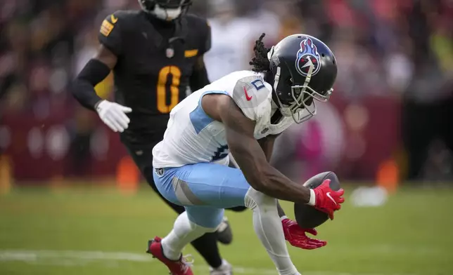 Tennessee Titans wide receiver Calvin Ridley (0), right, makes a catch past Washington Commanders cornerback Mike Sainristil (0), left, during the first half of an NFL football game Sunday, Dec. 1, 2024, in Landover, Md. (AP Photo/Matt Slocum)