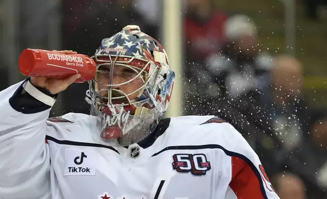 Washington Capitals' Charlie Lindgren sprays himself with water during the second period of an NHL hockey game against the New Jersey Devils, Saturday, Nov. 30, 2024, in Newark, N.J. (AP Photo/Pamela Smith)