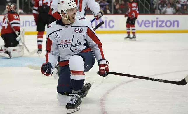 Washington Capitals' Taylor Raddysh celebrates after scoring during the third period of an NHL hockey game against the New Jersey Devils Saturday, Nov. 30, 2024, in Newark, N.J. (AP Photo/Pamela Smith)