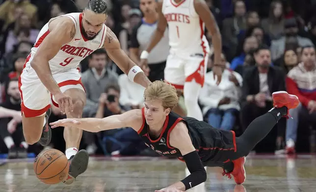 Toronto Raptors guard Gradey Dick, front right, and Houston Rockets forward Dillon Brooks (9) vie for the ball during first-half NBA basketball game action in Toronto, Sunday, Dec. 22, 2024. (Frank Gunn/The Canadian Press via AP)