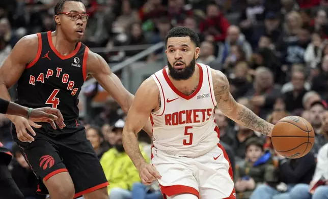 Houston Rockets guard Fred VanVleet (5) moves the ball while under pressure from Toronto Raptors forward Scottie Barnes (4) during first-half NBA basketball game action in Toronto, Sunday, Dec. 22, 2024. (Frank Gunn/The Canadian Press via AP)