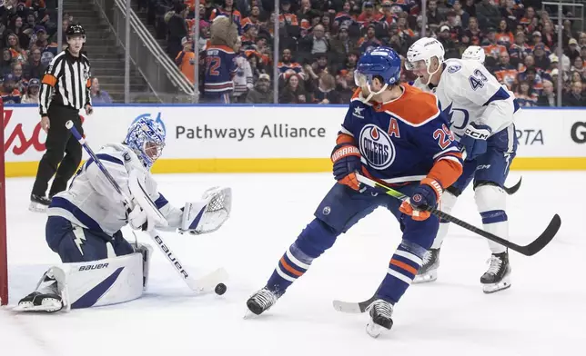 Tampa Bay Lightning goalie Andrei Vasilevskiy (88) makes a save on Edmonton Oilers' Leon Draisaitl (29) as Darren Raddysh (43) defends during the second period of an NHL hockey game, Tuesday, Dec. 10, 2024 in Edmonton, Alberta. (Jason Franson/The Canadian Press via AP)