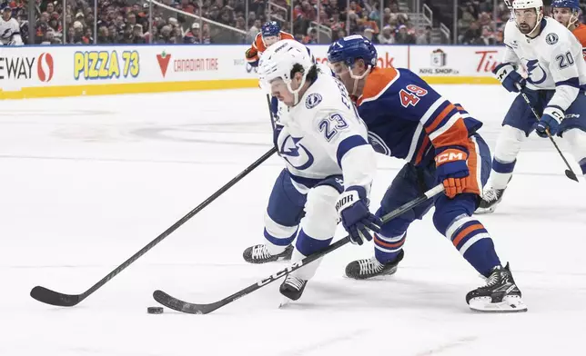 Tampa Bay Lightning's Mikey Eyssimont (23) tries to hold off Edmonton Oilers' Ty Emberson (49) during the third period of an NHL hockey game, Tuesday, Dec. 10, 2024 in Edmonton, Alberta. (Jason Franson/The Canadian Press via AP)