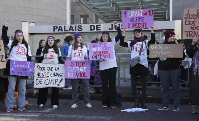 FILE - Activists hold posters in front of the Palace of Justice during a women's rights demonstration on Dec. 14, 2024, in Avignon, southern France, where the trial of dozens of men accused of raping Gisèle Pelicot while she was drugged and rendered unconscious by her husband is taking place. (AP Photo/Aurelien Morissard, File)