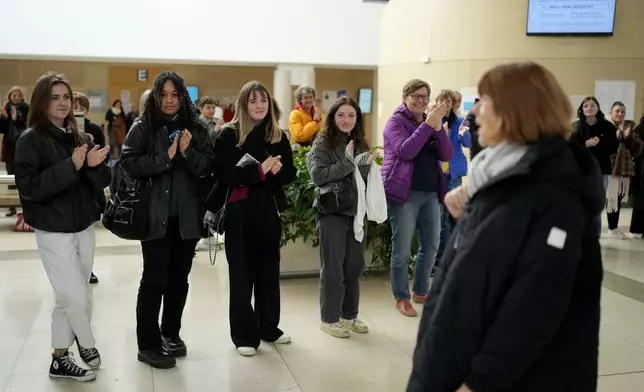 FILE - People applaud Gisèle Pelicot, front right, who was allegedly drugged by her then-husband so that he and others could sexually assault her, leaves the courthouse in Avignon, southern France, on Dec. 9, 2024. (AP Photo/Lewis Joly, File)