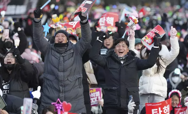 Participants celebrate after hearing the news that South Korea's parliament voted to impeach President Yoon Suk Yeol outside the National Assembly in Seoul, South Korea, Saturday, Dec. 14, 2024. (AP Photo/Lee Jin-man)