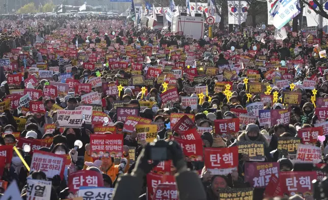 People shout slogans during a rally to demand South Korean President Yoon Suk Yeol's impeachment outside the National Assembly in Seoul, South Korea, Saturday, Dec. 14, 2024. The letters read "Impeachment." (AP Photo/Lee Jin-man)