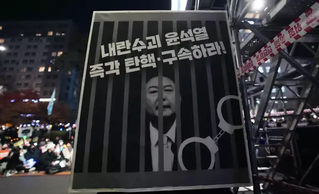 An image of depicting an imprisoned South Korean President Yoon Suk Yeol is displayed during a rally to demand his impeachment outside the National Assembly in Seoul, South Korea, Friday, Dec. 13, 2024. The signs read "Arrest and impeach the rebellion leader Yoon Suk Yeol." (AP Photo/Ahn Young-joon)