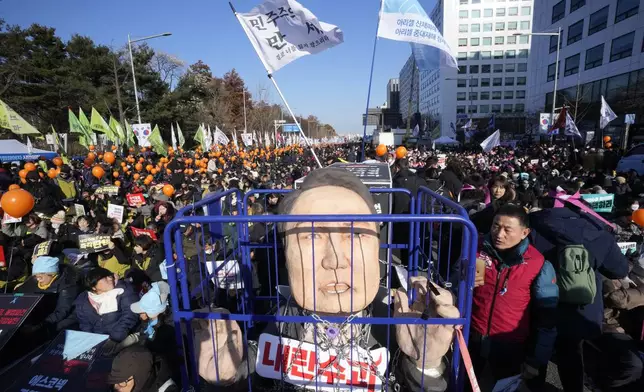 A caricature depicting an imprisoned South Korean President Yoon Suk Yeol is displayed before a rally to demand his impeachment outside the National Assembly in Seoul, South Korea, Saturday, Dec. 14, 2024. (AP Photo/Ahn Young-joon)