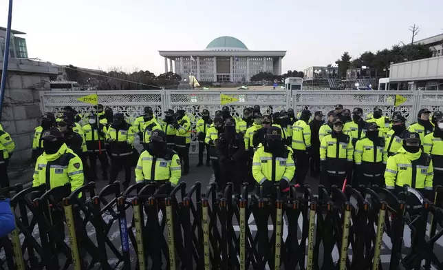 Police officers stand guard in front of the National Assembly in Seoul, South Korea, Saturday, Dec. 14, 2024. (AP Photo/Lee Jin-man)