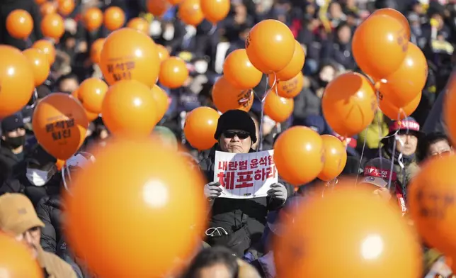 A man holds a sign reading "Arrest Yoon Suk Yeol" during a rally to demand South Korean President Yoon Suk Yeol's impeachment outside the National Assembly in Seoul, South Korea, Saturday, Dec. 14, 2024. (AP Photo/Lee Jin-man)