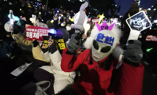 Participants attend a rally to demand South Korean President Yoon Suk Yeol's impeachment outside the National Assembly in Seoul, South Korea, Friday, Dec. 13, 2024. (AP Photo/Ahnn Young-joon)