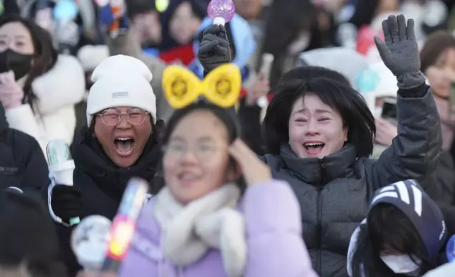 Participants react after hearing the news of South Korean President Yoon Suk Yeol's impeachment outside the National Assembly in Seoul, South Korea, Saturday, Dec. 14, 2024. (AP Photo/Lee Jin-man)