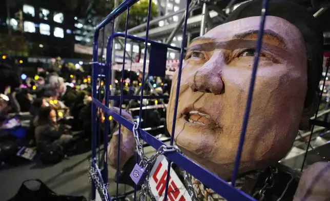 A caricature depicting an imprisoned South Korean President Yoon Suk Yeol is displayed during a rally to demand his impeachment outside the National Assembly in Seoul, South Korea, Friday, Dec. 13, 2024. (AP Photo/Ahnn Young-joon)