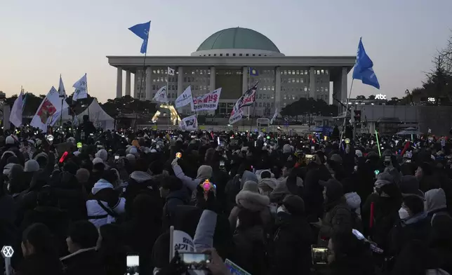 Participants react after hearing the news that South Korea's parliament voted to impeach President Yoon Suk Yeol outside the National Assembly in Seoul, South Korea, Saturday, Dec. 14, 2024. (AP Photo/Lee Jin-man)