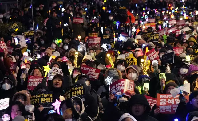 Participants stage a rally, to demand South Korean President Yoon Suk Yeol's impeachment, outside the National Assembly in Seoul, South Korea, Friday, Dec. 13, 2024. (AP Photo/Ahnn Young-joon)