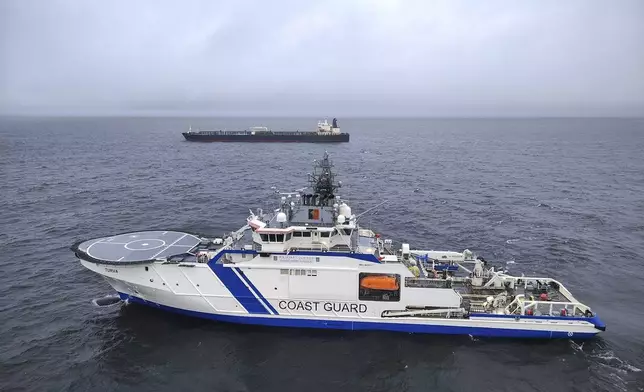 This photo provided by Rajavartiosto (Finnish Border Guard) on Thursday, Dec. 26, 2024, shows the oil tanker Eagle S, background, and the Finnish Border Guard ship Turva at sea outside Porkkalanniemi, Finland. The Eagle S was sailing at the same time in the area where the Finland-Estonia electrical link was disrupted on Wednesday. (Rajavartiosto via AP)