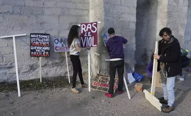 Activists prepare posters before a women's rights demonstration, Saturday, Dec. 14, 2024 in Avignon, southern France, where the trial of dozens of men accused of raping Gisèle Pelicot while she was drugged and rendered unconscious by her husband is taking place. (AP Photo/Aurelien Morissard)