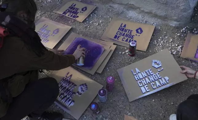 An activist prepares posters before a women's rights demonstration Saturday, Dec. 14, 2024 in Avignon, southern France, where the trial of dozens of men accused of raping Gisèle Pelicot while she was drugged and rendered unconscious by her husband is taking place. (AP Photo/Aurelien Morissard)