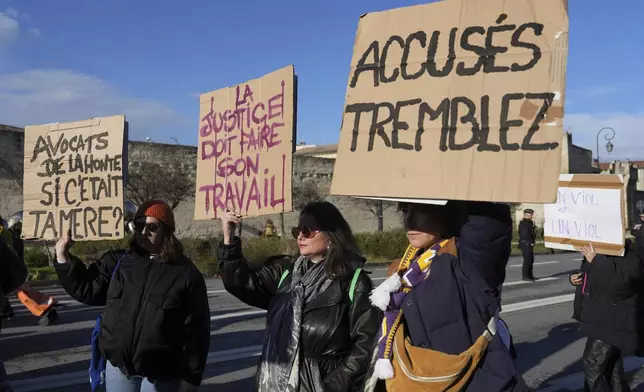 Activists hold posters during a women's rights demonstration, Saturday, Dec. 14, 2024 in Avignon, southern France, where the trial of dozens of men accused of raping Gisèle Pelicot while she was drugged and rendered unconscious by her husband is taking place. (AP Photo/Aurelien Morissard)