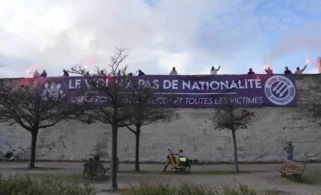 Activists display a banner reading "Rape has no nationality" during a women's rights demonstration, Saturday, Dec. 14, 2024 in Avignon, southern France, where the trial of dozens of men accused of raping Gisèle Pelicot while she was drugged and rendered unconscious by her husband is taking place. (AP Photo/Aurelien Morissard)