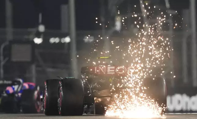 Mercedes driver Lewis Hamilton of Britain creates sparks as his car touches the track during the qualifying for the Formula One Abu Dhabi Grand Prix at the Yas Marina Circuit in Abu Dhabi, UAE, Saturday, Dec. 7, 2024. (AP Photo/Altaf Qadri)