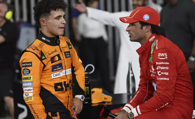 McLaren driver Lando Norris of Britain, left, talks to Ferrari driver Carlos Sainz of Spain after winning the pole position during the qualifying for the Formula One Abu Dhabi Grand Prix at the Yas Marina Circuit in Abu Dhabi, UAE, Tuesday, Jan. 9, 2024. (AP Photo/Hamad I Mohammed, Pool)