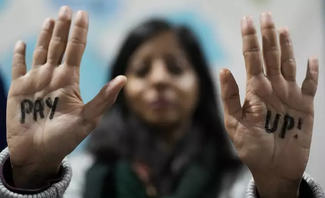 FILE - A demonstrator displays hands that read "pay up" during a protest for climate finance at the COP29 U.N. Climate Summit, Nov. 23, 2024, in Baku, Azerbaijan. (AP Photo/Rafiq Maqbool, File)